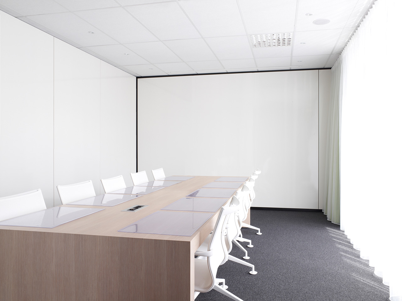 modern meeting room with white chairs and wooden conference table